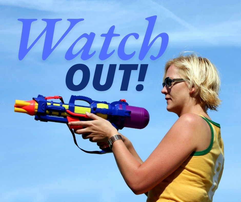 A blonde lady stands side on pointing a large water pistol. The words Watch Out are on the image too! Barcelona Baby!