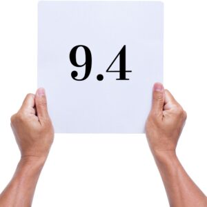 hands holding up a 9.4 score card